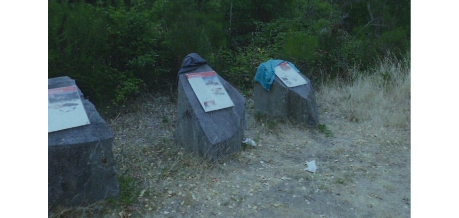 Steine mit Informationstexten sind mit Müll beladen