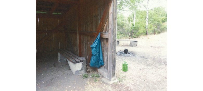 Ein blauer Müllsack hängt in der Hütte an einem Balken