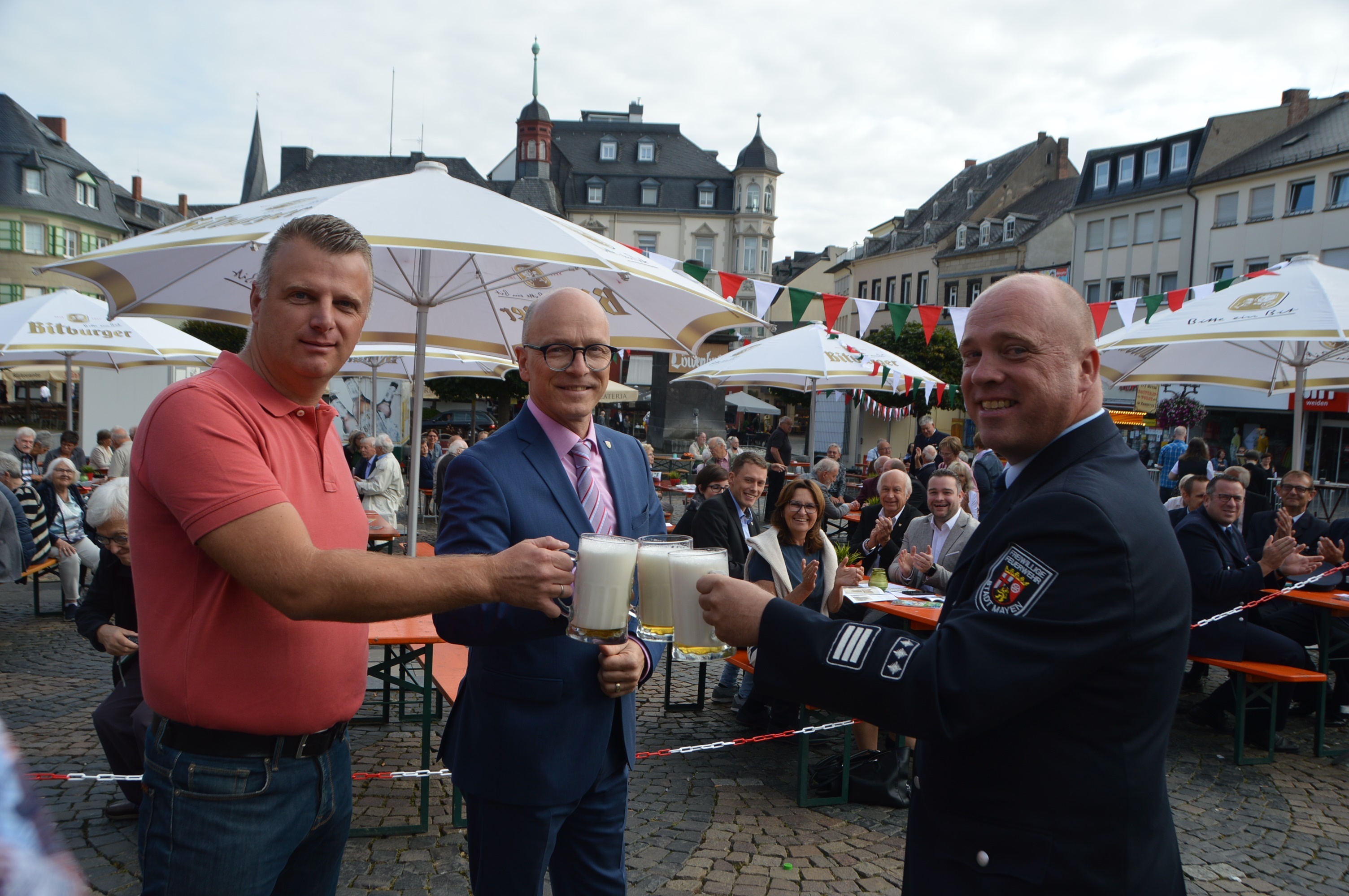 Drei Personen stoßen zusammen an