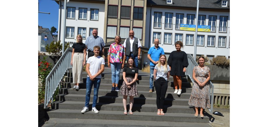 10 Personen stehen auf der Treppe vor der Stadtverwaltung