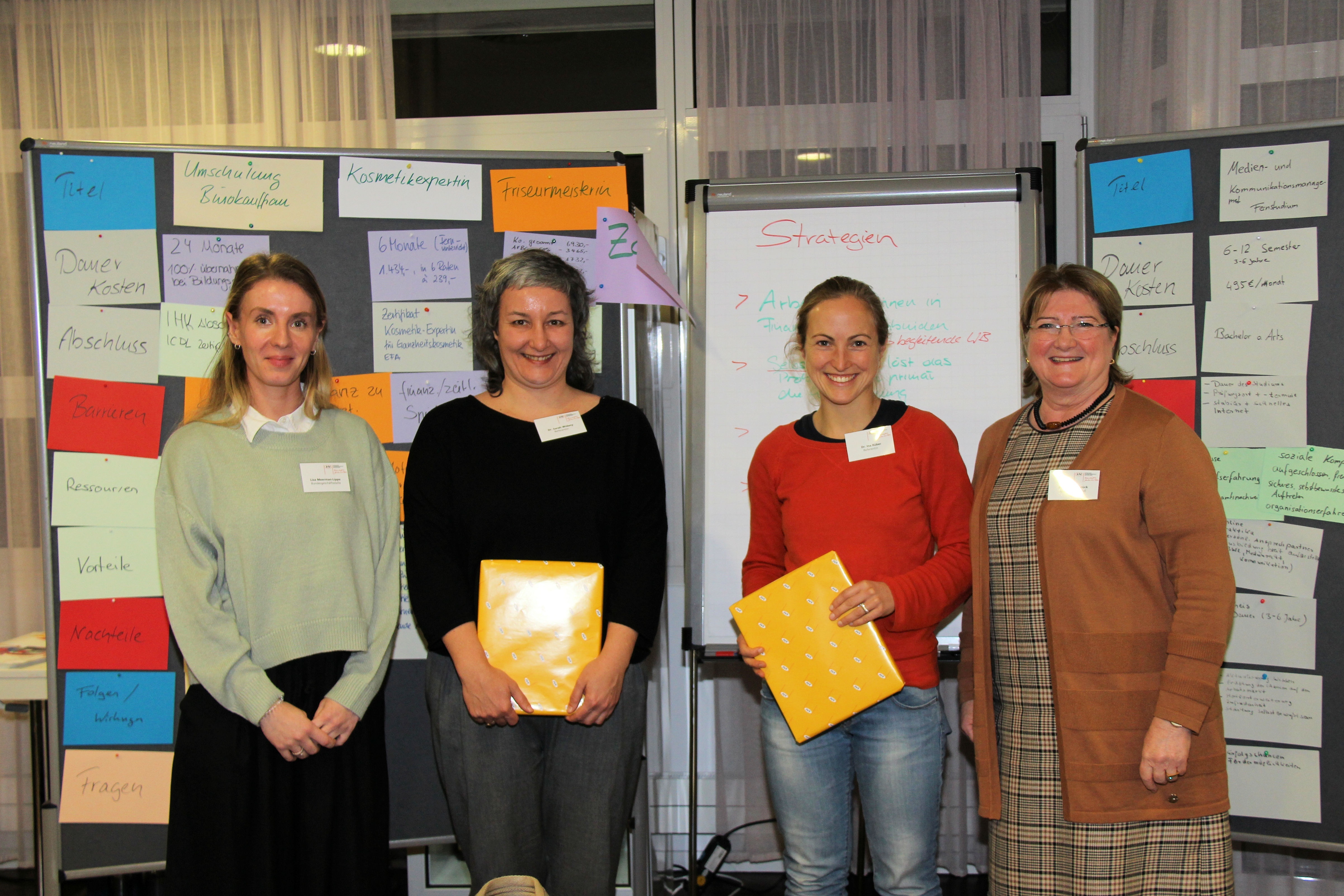 4 Personen vor verschiedenen Stellwänden