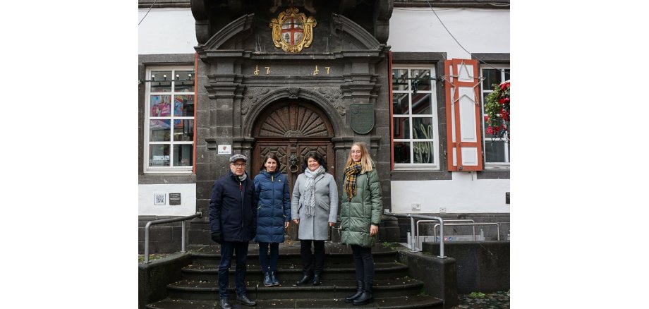 vier Personen stehen vor dem Alten Rathaus 