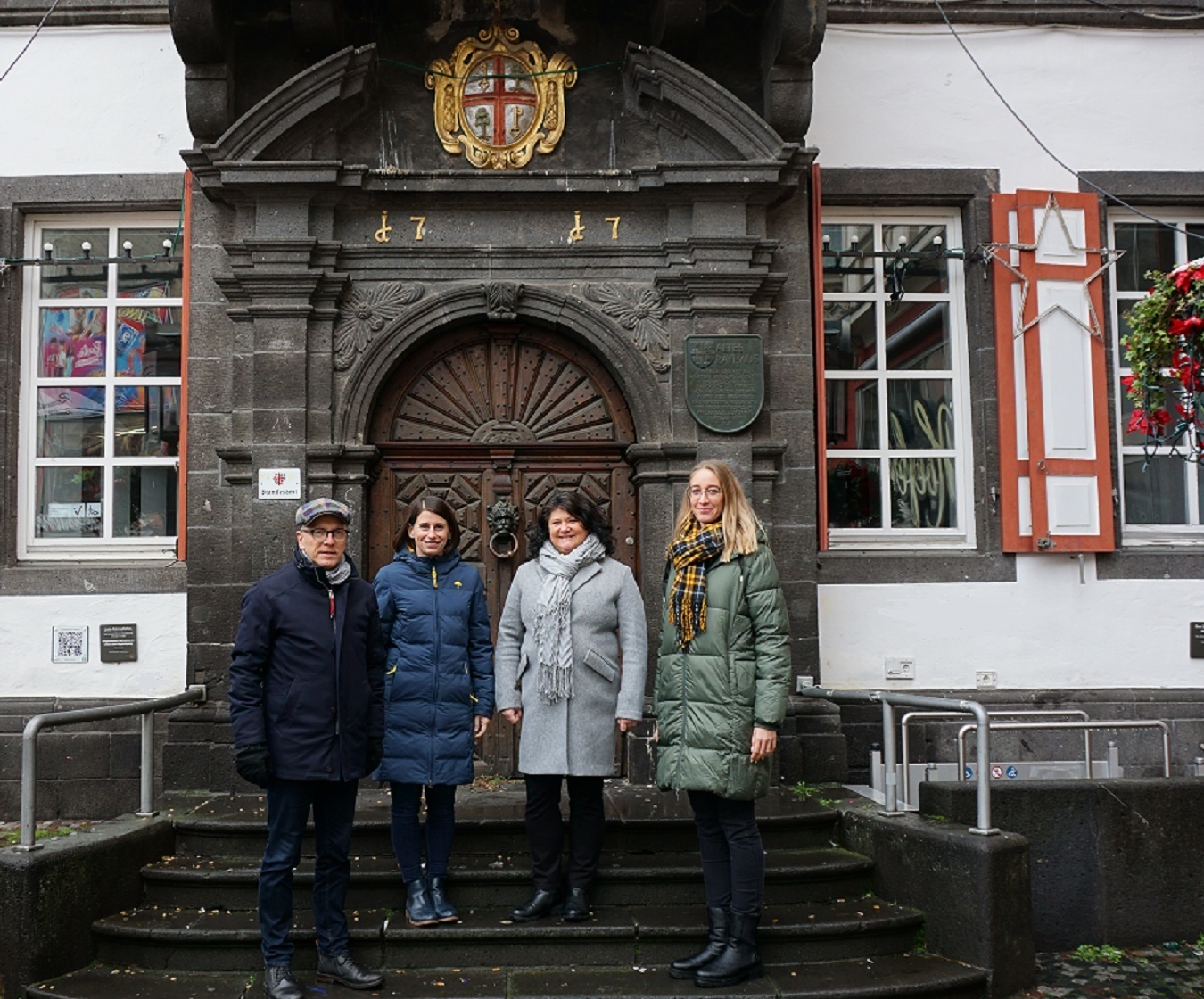 vier Personen stehen vor dem Alten Rathaus 