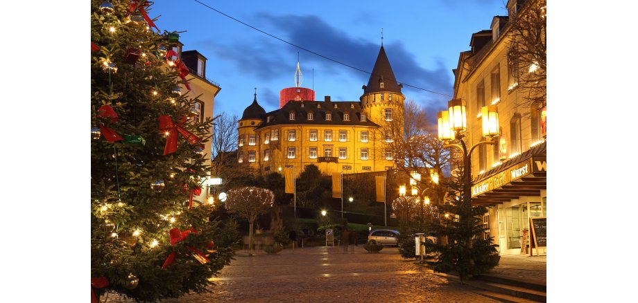 Marktplatz und weihnachtlich beleuchtete Genovevaburg in der Dämmerung