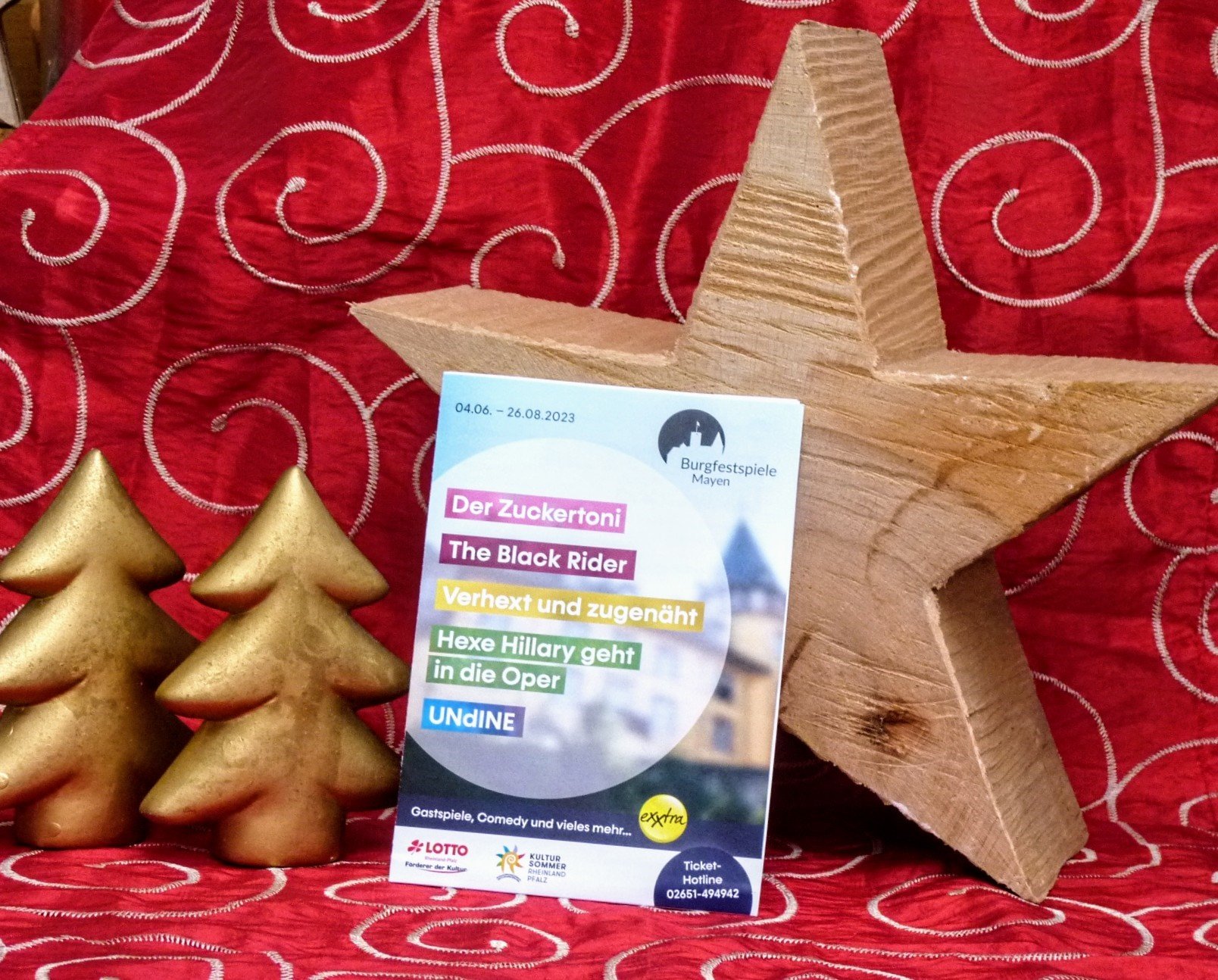 Der neue Flyer zu der Festspielsaison vor weihnachtlicher Deko positioniert