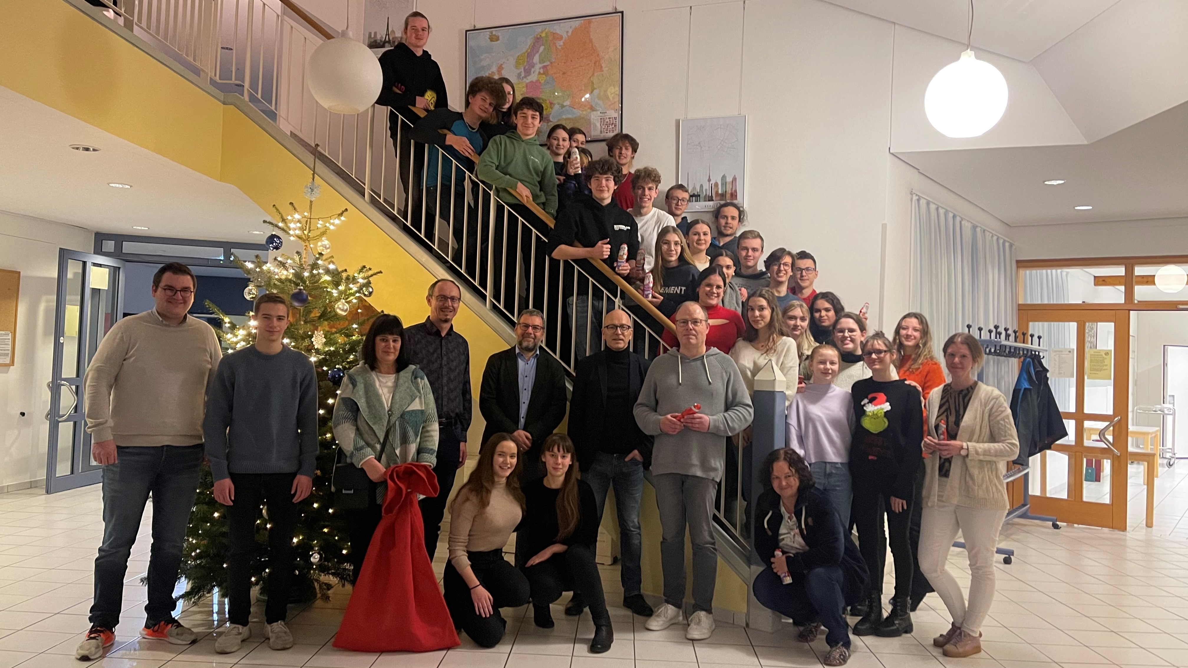 Personengruppe steht vor und auf einer Treppe zum Gruppenbild zusammen