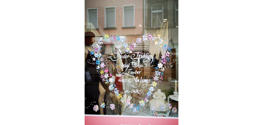 verziertes Schaufenster mit einem Spruch Jeder Frühling trägt den Zauber eines Anfangs in sich