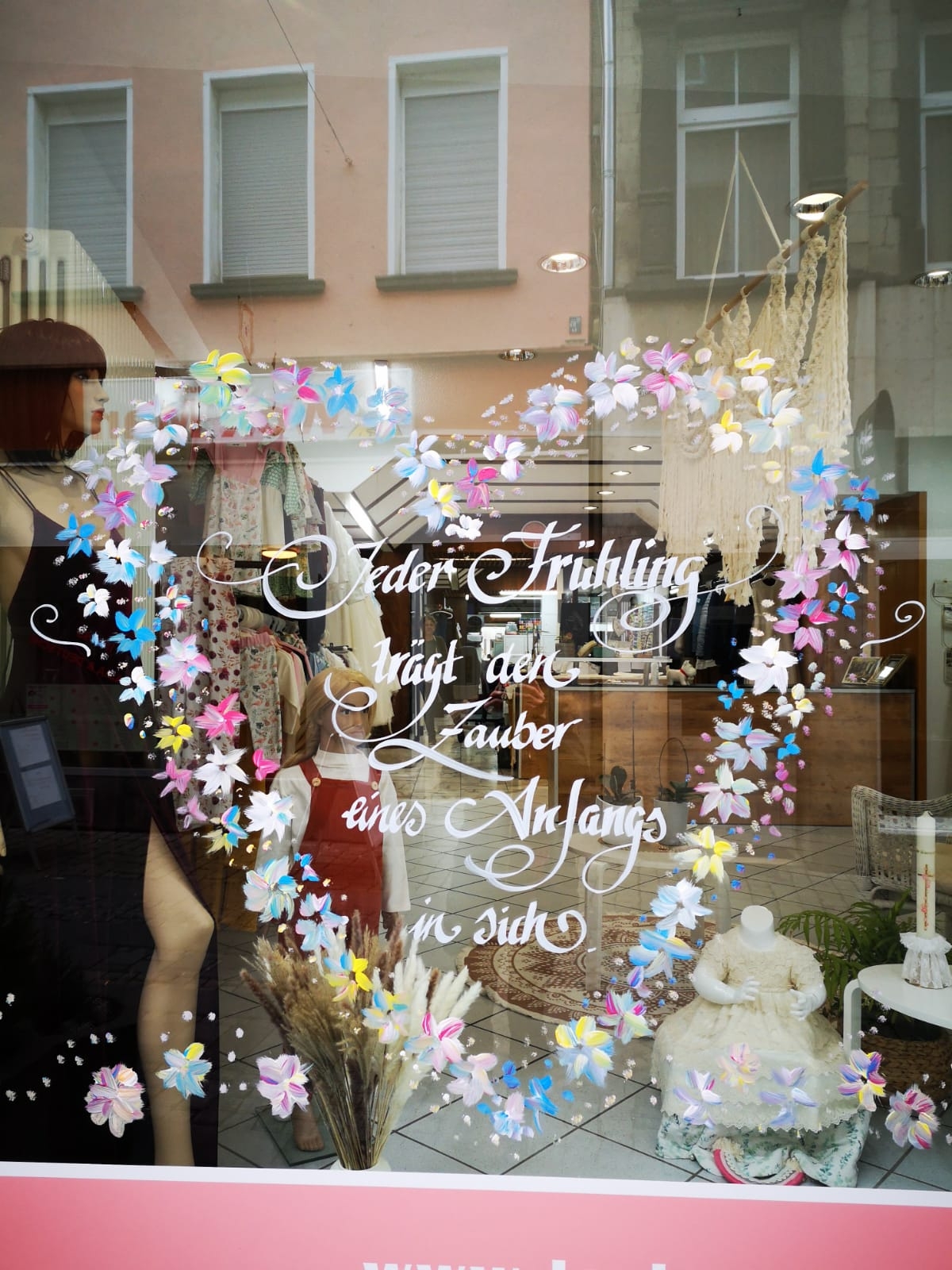 verziertes Schaufenster mit einem Spruch Jeder Frühling trägt den Zauber eines Anfangs in sich