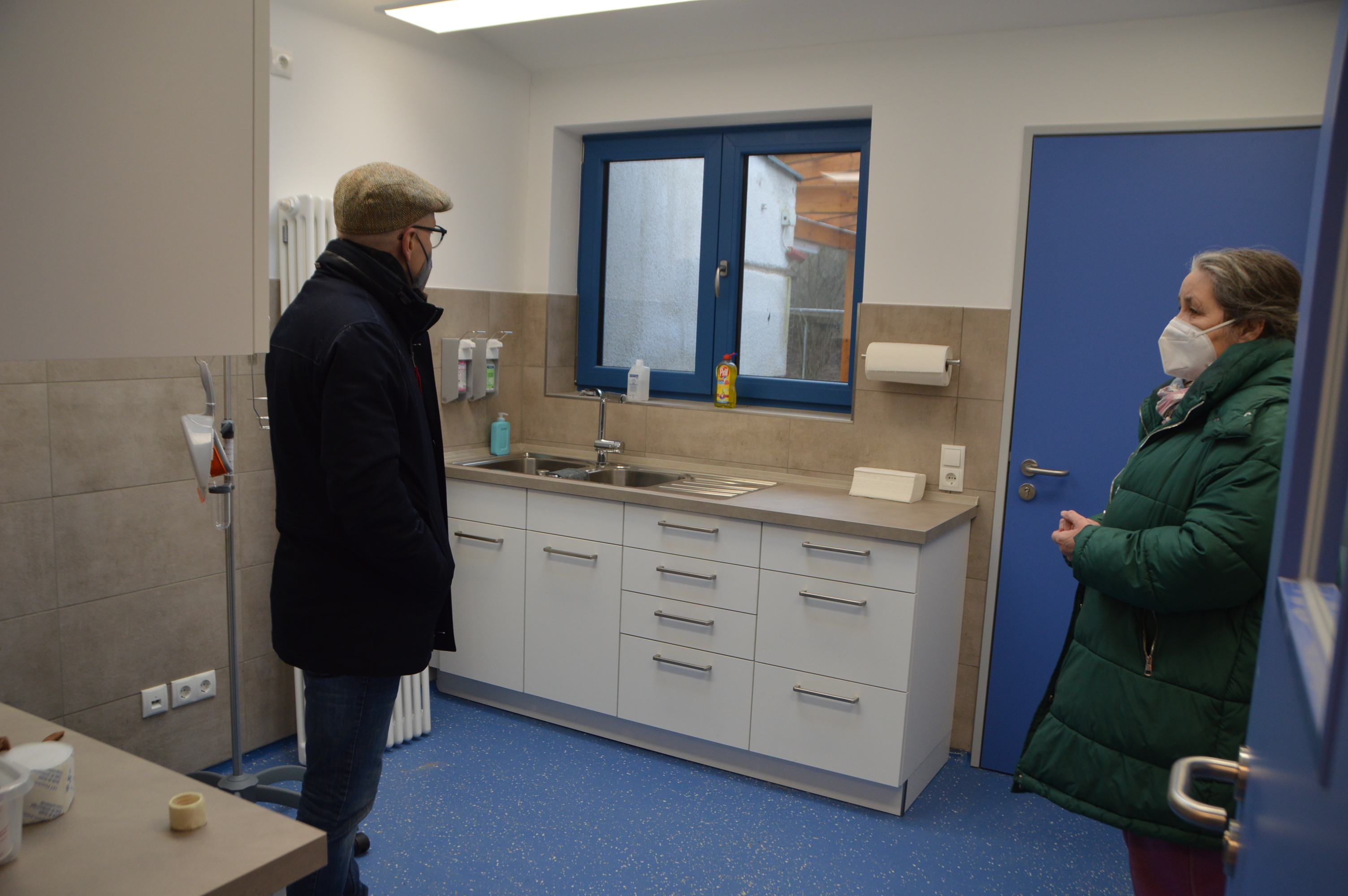 1 Mann (linke Seite) mit Hut  und 1 Frau (rechte Seite) stehen im Arztzimmer im Tierheim Mayen