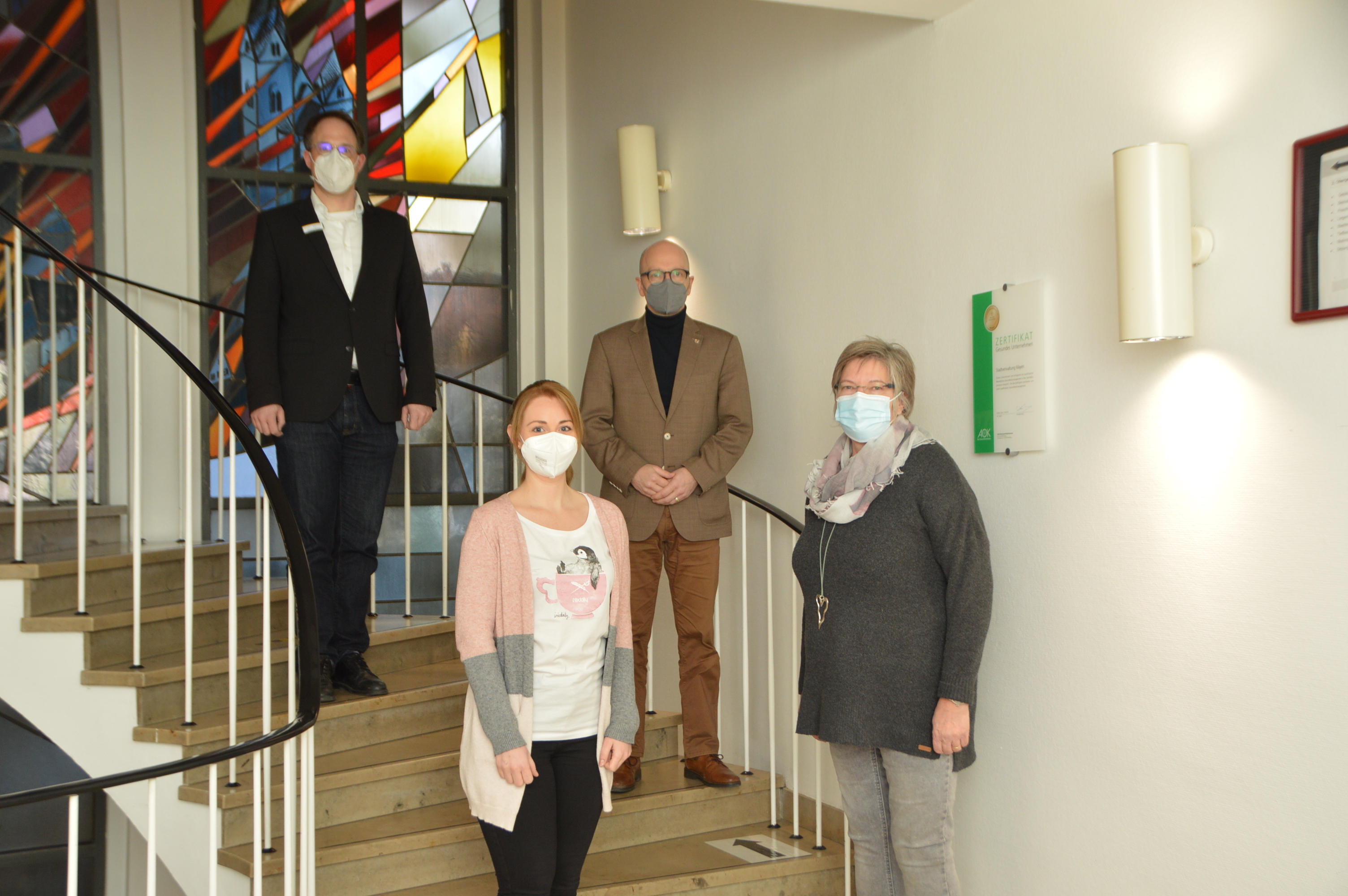 von links nach rechts: Büroleiter Christoph Buttner, Oberbürgermeister Dirk Meid, Bianka Weiland und Monika Haupt auf der Treppe in der Stadtverwaltung Mayen.- Alle Anwesenden hielten genug Abstand und trugen eine Maske
