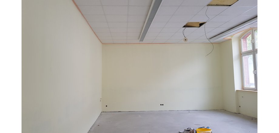 Ein Raum der renoviert wird. Es hängen noch Kabel aus der Decke und Steckdosen sitzen auch noch keine