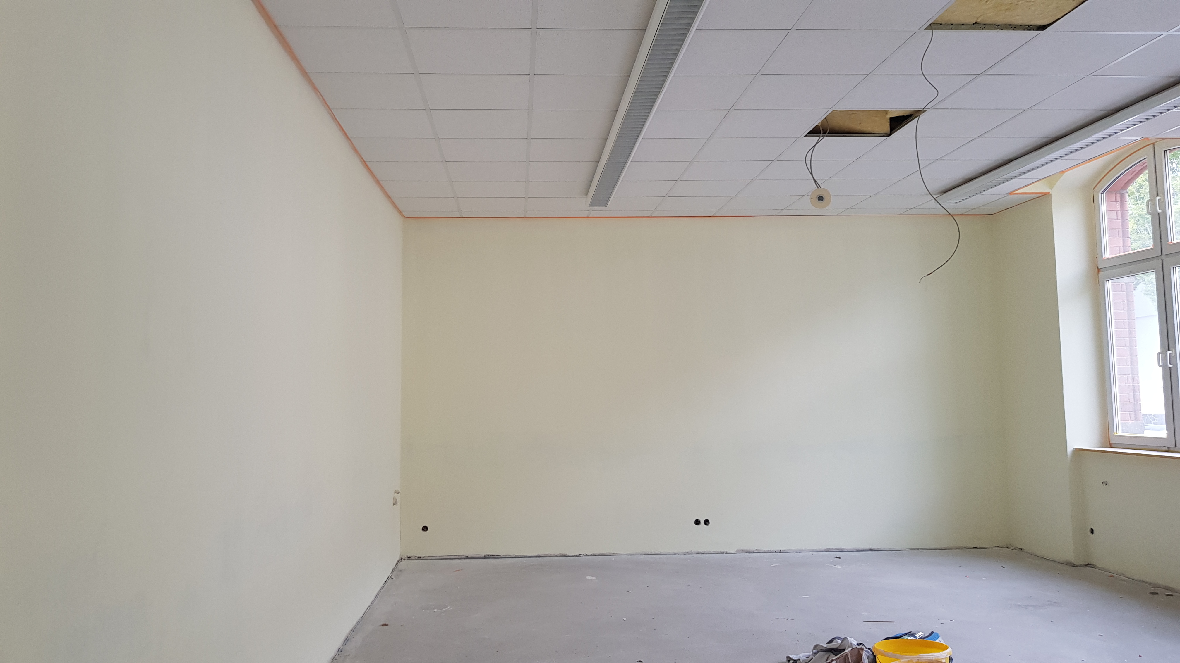 Ein Raum der renoviert wird. Es hängen noch Kabel aus der Decke und Steckdosen sitzen auch noch keine