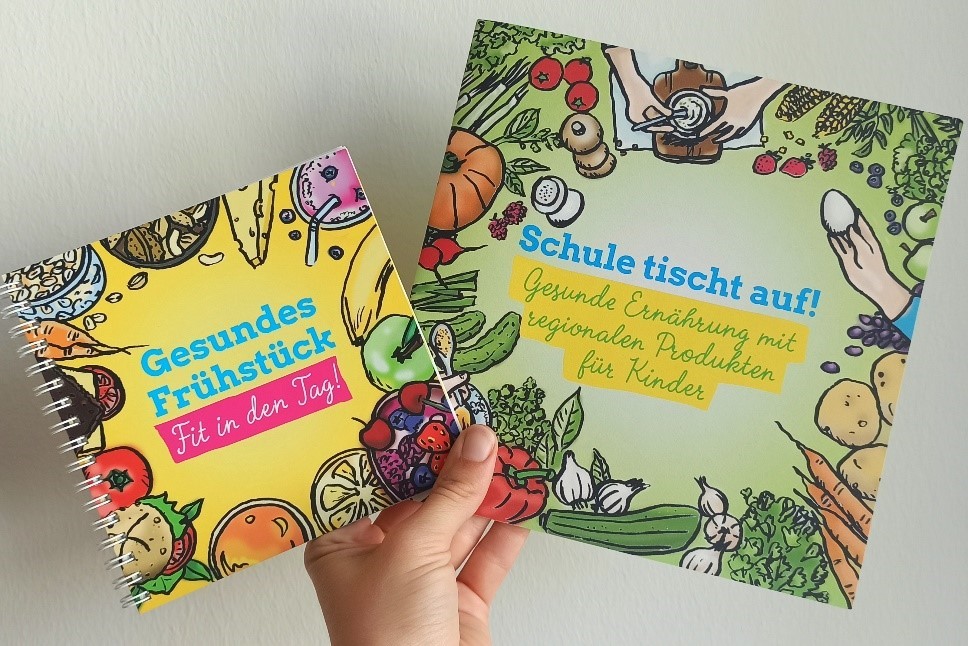 Zwei Infobroschüren von einer Hand gehalten