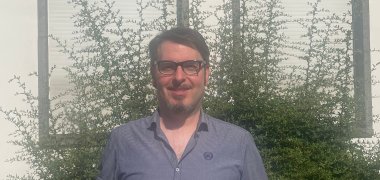 Tobias Härtling mit einer Broschüre in der Hand vor dem Rathaus