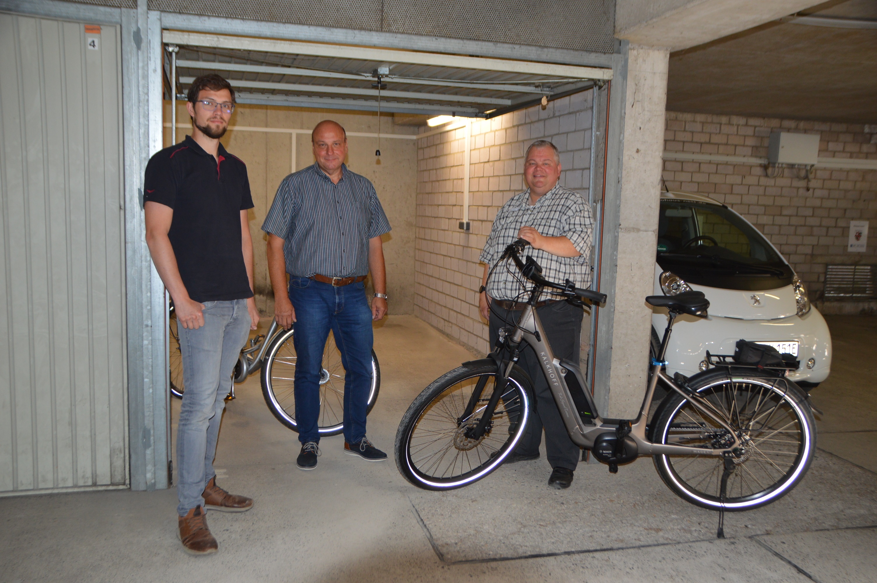 v.l.n.r.: Klimaschutzbeauftragter der Stadt Mayen, Klaus Künzer, als Vorsitzender des Arbeitskreises „Betriebliches Gesundheitsmanagement“ und Wolfgang Goeken, Personalratsvorsitzender vor den neuen Garagen für die E-Bikes 