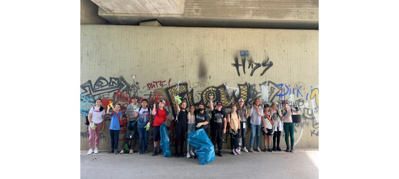 Die Helferinnen und Helfer unter einer Brück mit Müllzangen und Müllsäcken