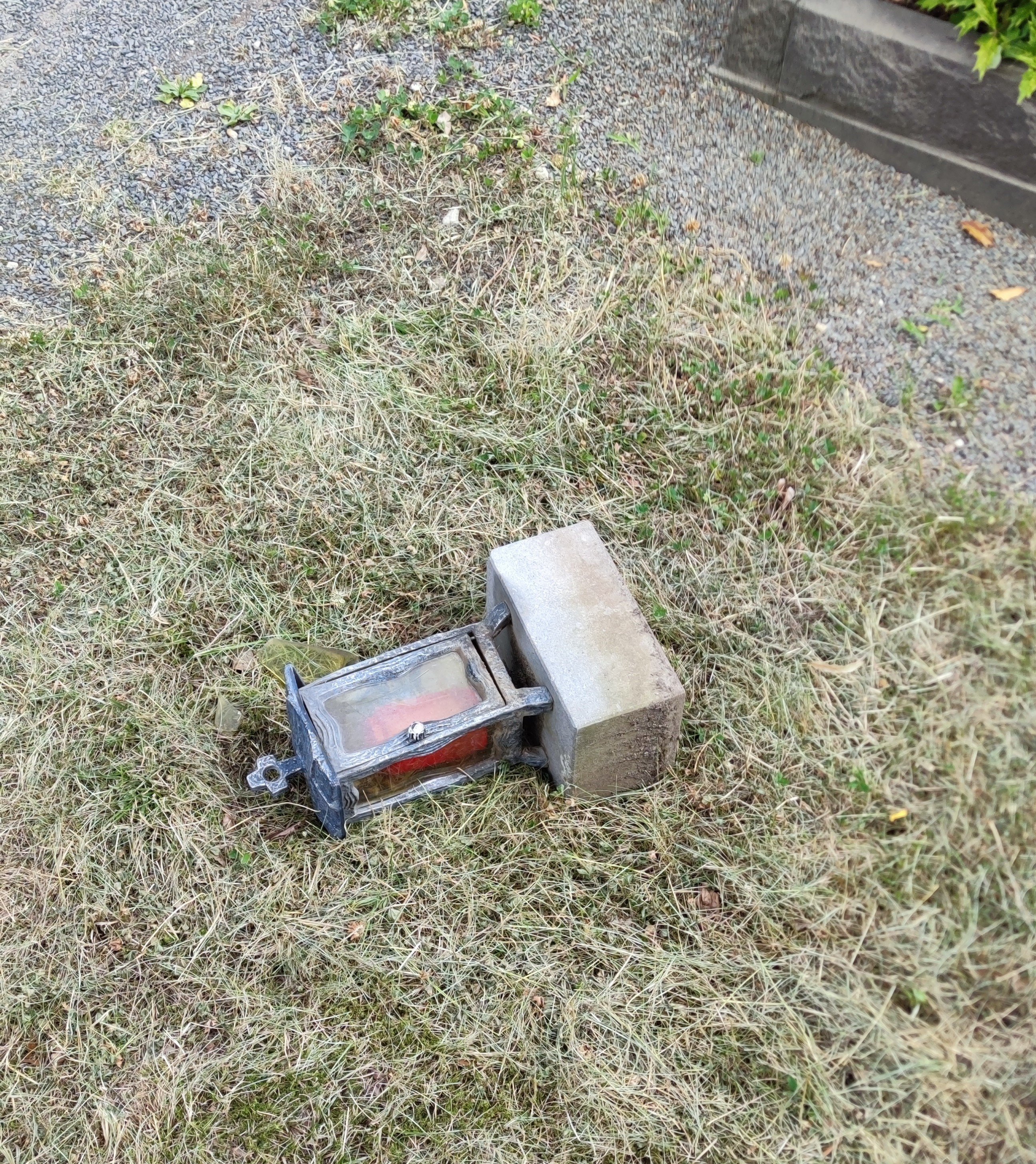 Zerstörtes Grablicht auf dem Boden