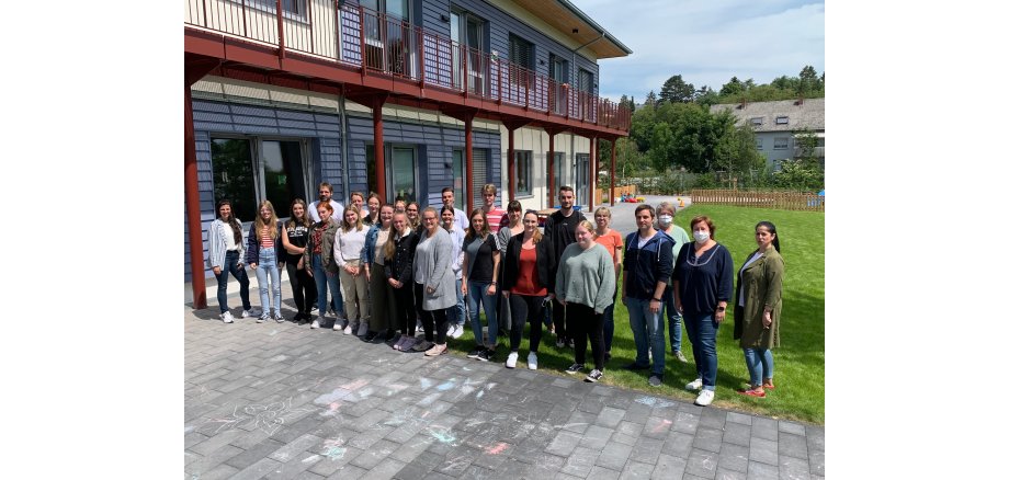 Eine Schulklasse und die Verantwortlichen vor dem Rasen der Kita Weiersbach