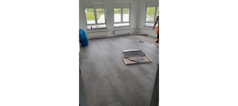 Verlegung eines Bodenbelages durch die Mitarbeiter