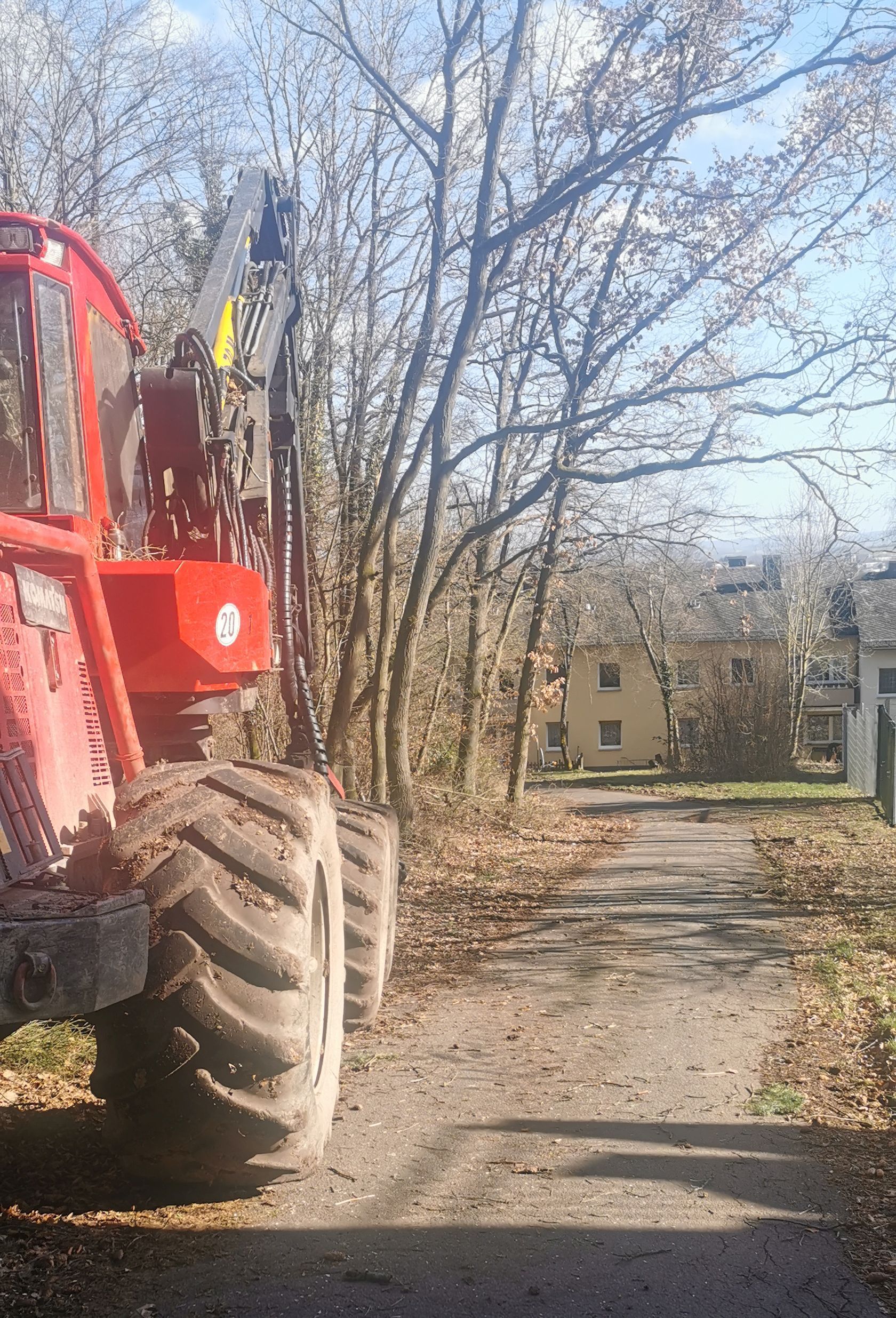 roter Bagger links auf einem Feldweg