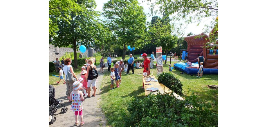 Buntes Treiben bei verschiedenen Ständen und einer Hüpfburg im Burggarten