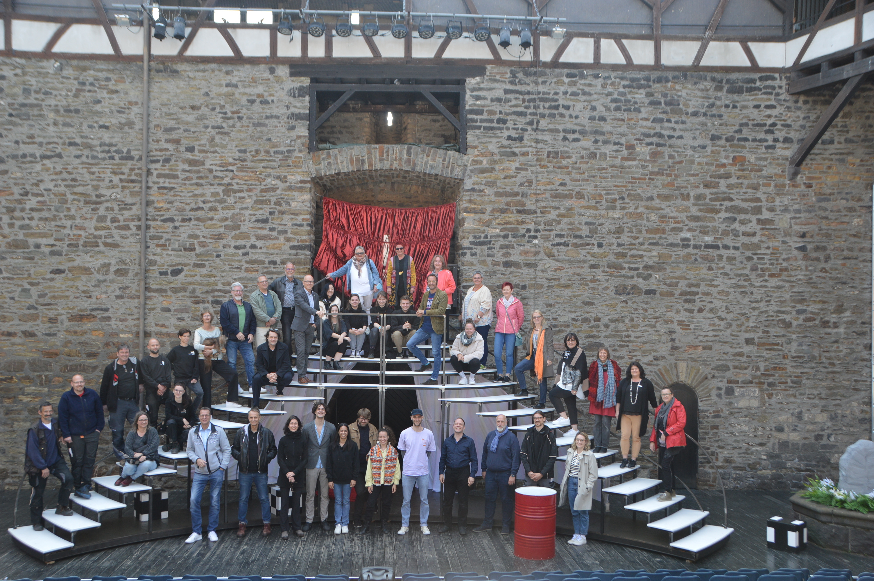 Das Ensemble auf einer Treppe auf der Bühne im Burginnenhof