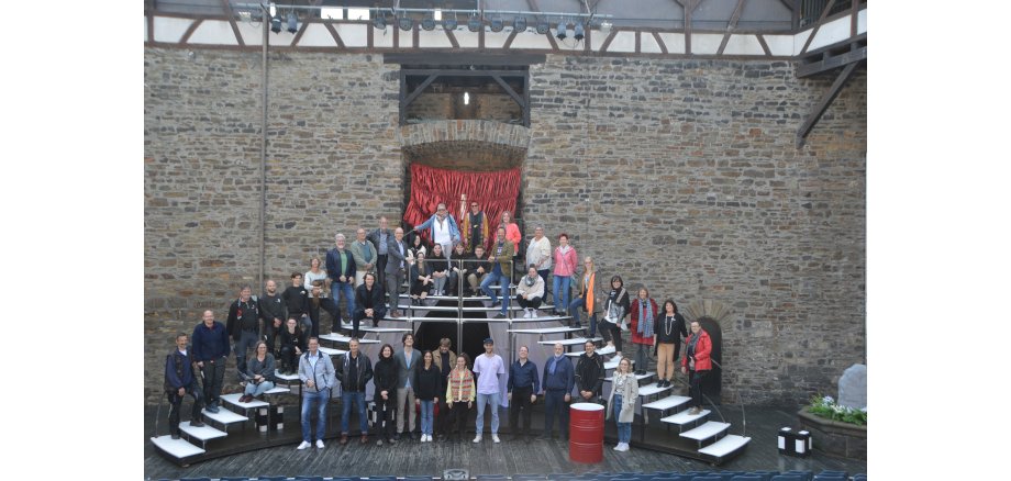 Das Ensemble auf einer Treppe auf der Bühne im Burginnenhof