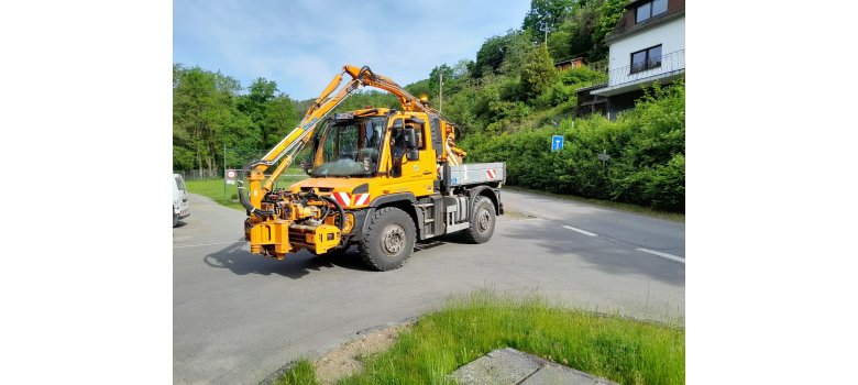 Unimog mit einem Auslegemulschgerät