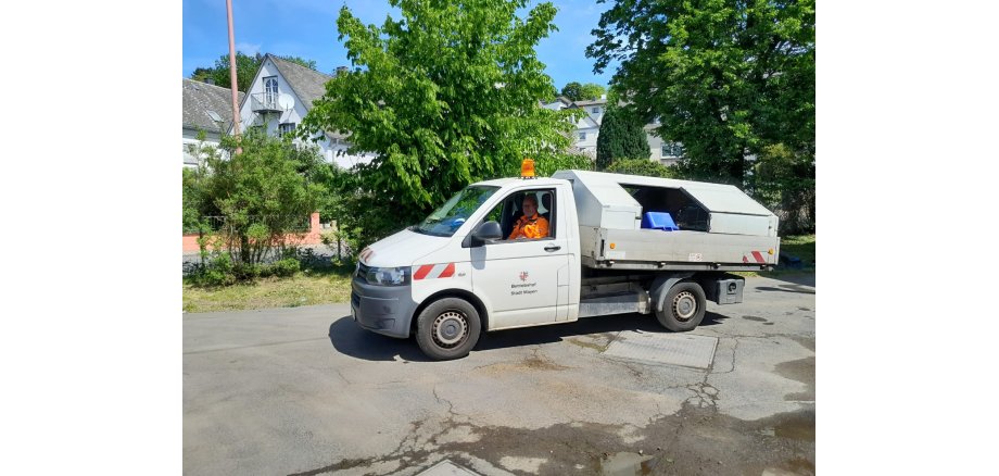 Mitarbeiter in einem Transporter mit Ladefläche im Einsatz für den Betriebshof