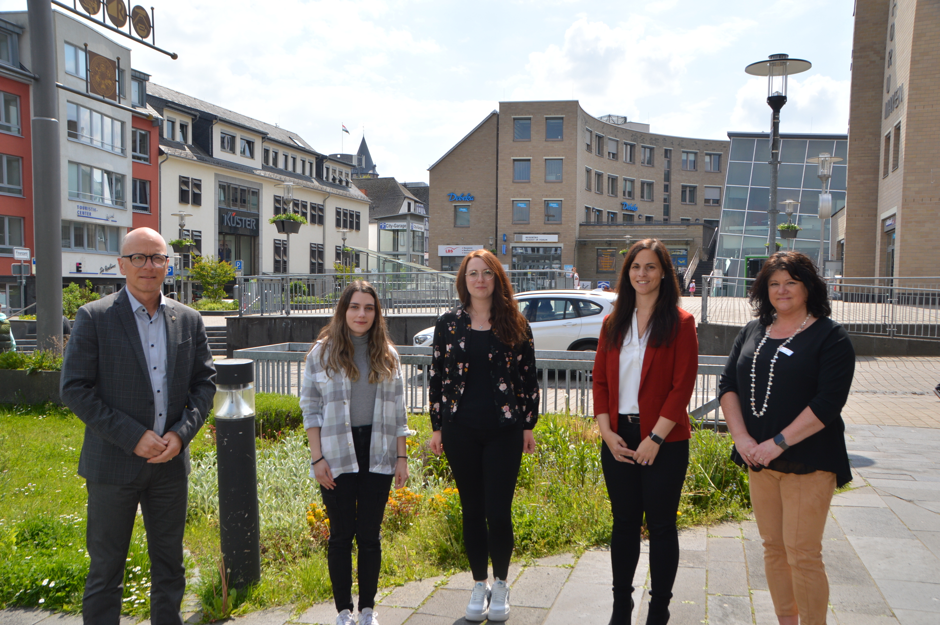 Oberbürgermeister Dirk Meid, Desponia Athanasiadou, Jennifer Fuhrmann, Büroleiterin Jasmin Alter und Dagmar Luxem vom Personalrat stehen in Reihe vor einer Wiese am Rathaus