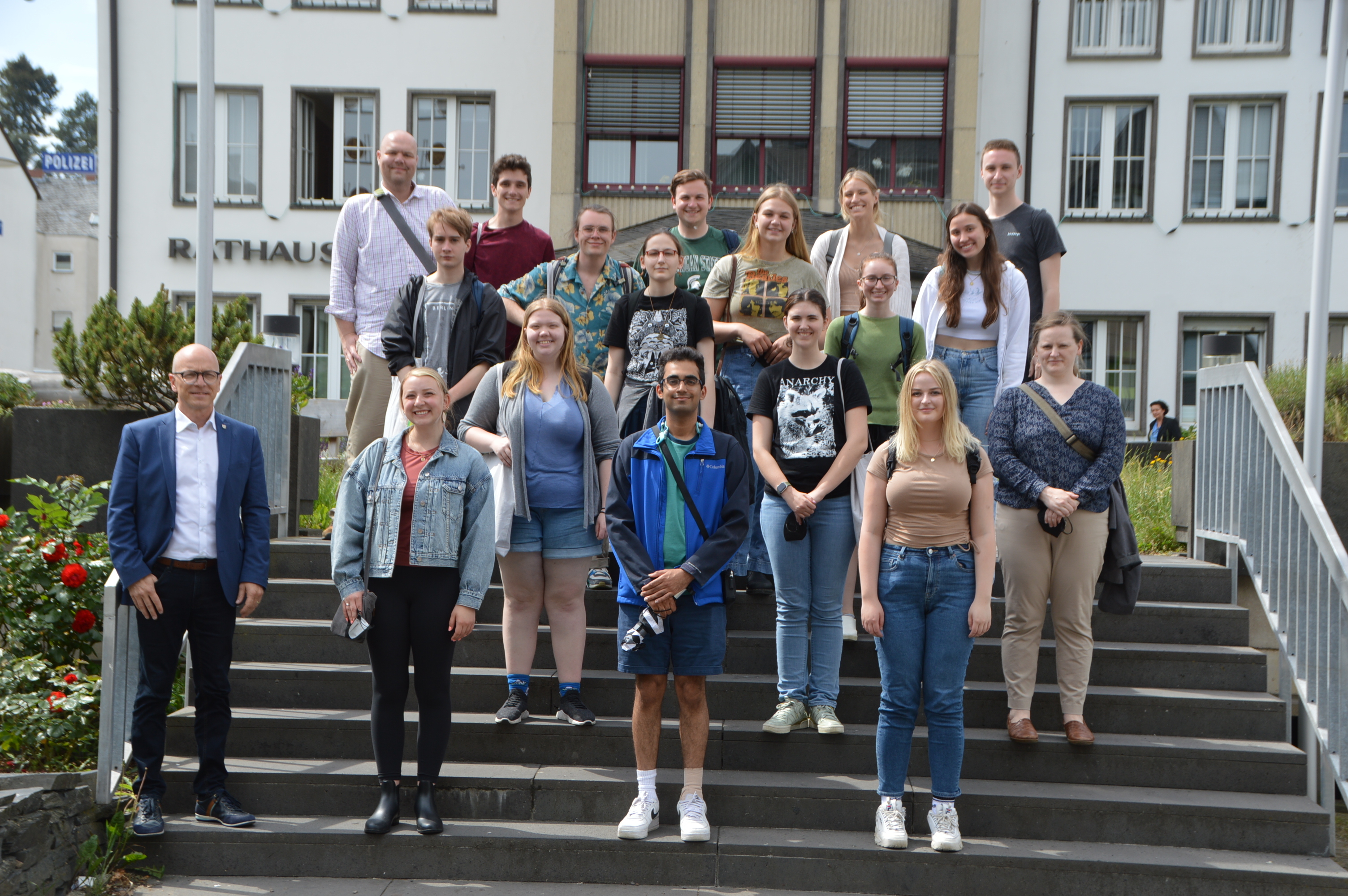Die Studentengruppe steht mit Oberbürgermeister Dirk Meid auf der Treppe  vor dem Rathaus