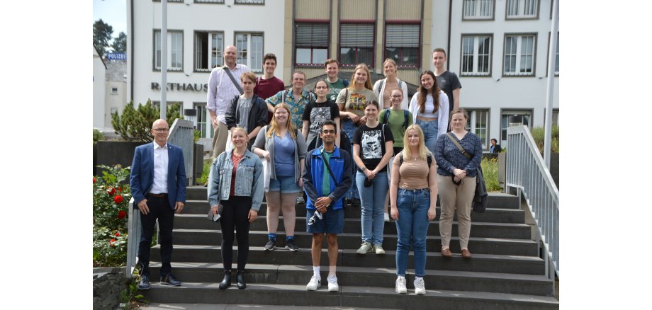 Die Studentengruppe steht mit Oberbürgermeister Dirk Meid auf der Treppe  vor dem Rathaus