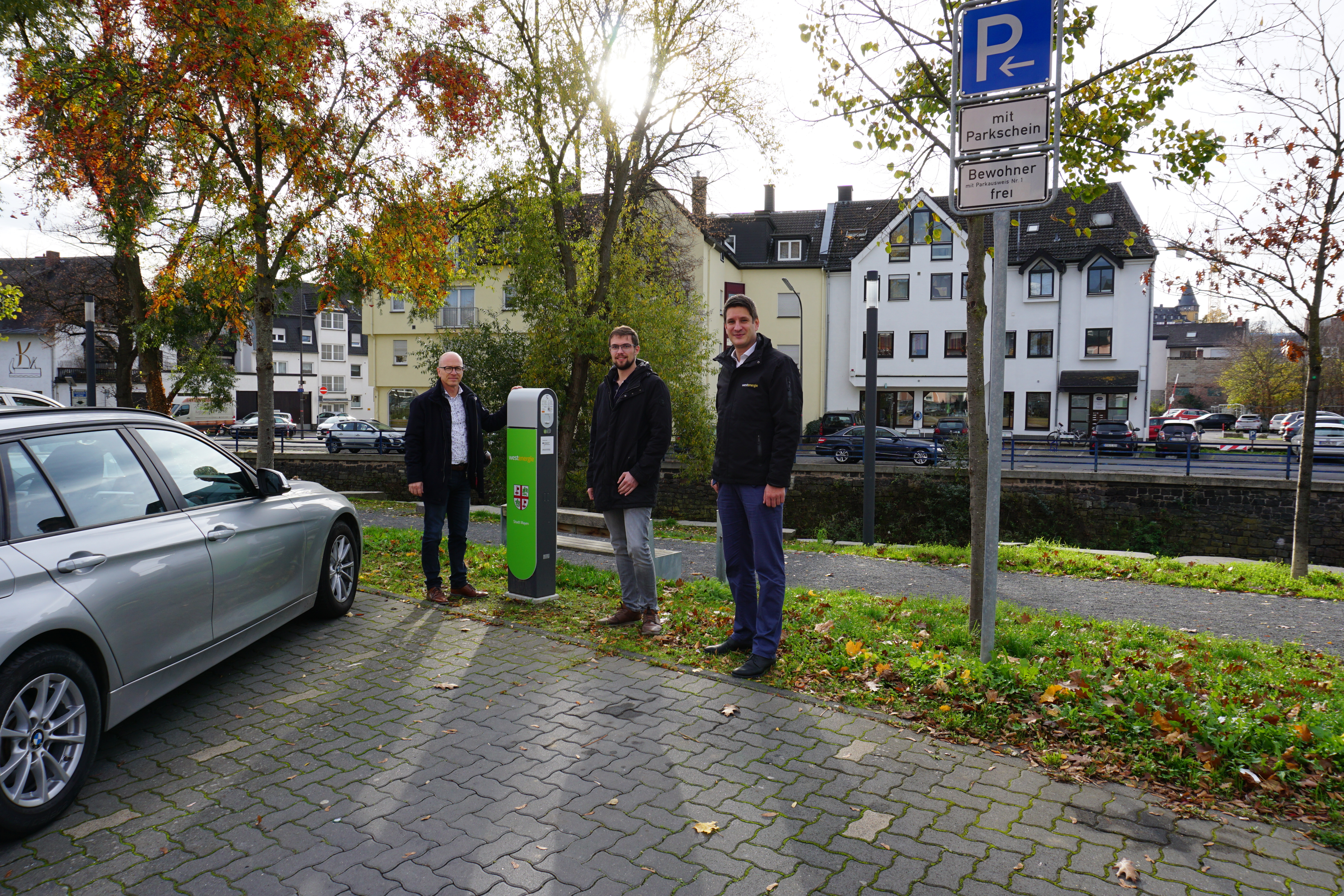 3 Personen an einer E-Ladesäule