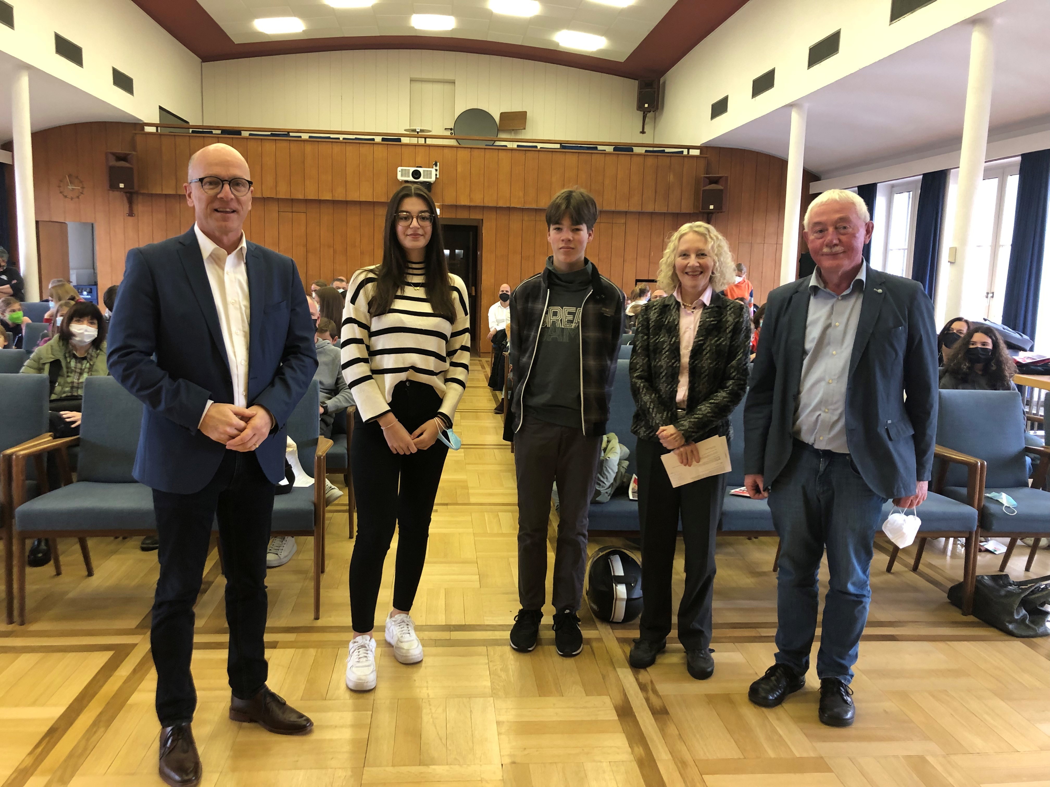 5 Personen stehen in einem Raum zu einem Gruppenfoto zusammen