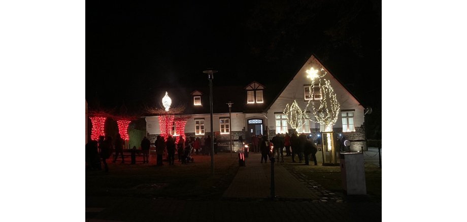 Weihnachtlich beleuchteter Platz im Dunkeln - es ist zu Adventskranz zu erkennen