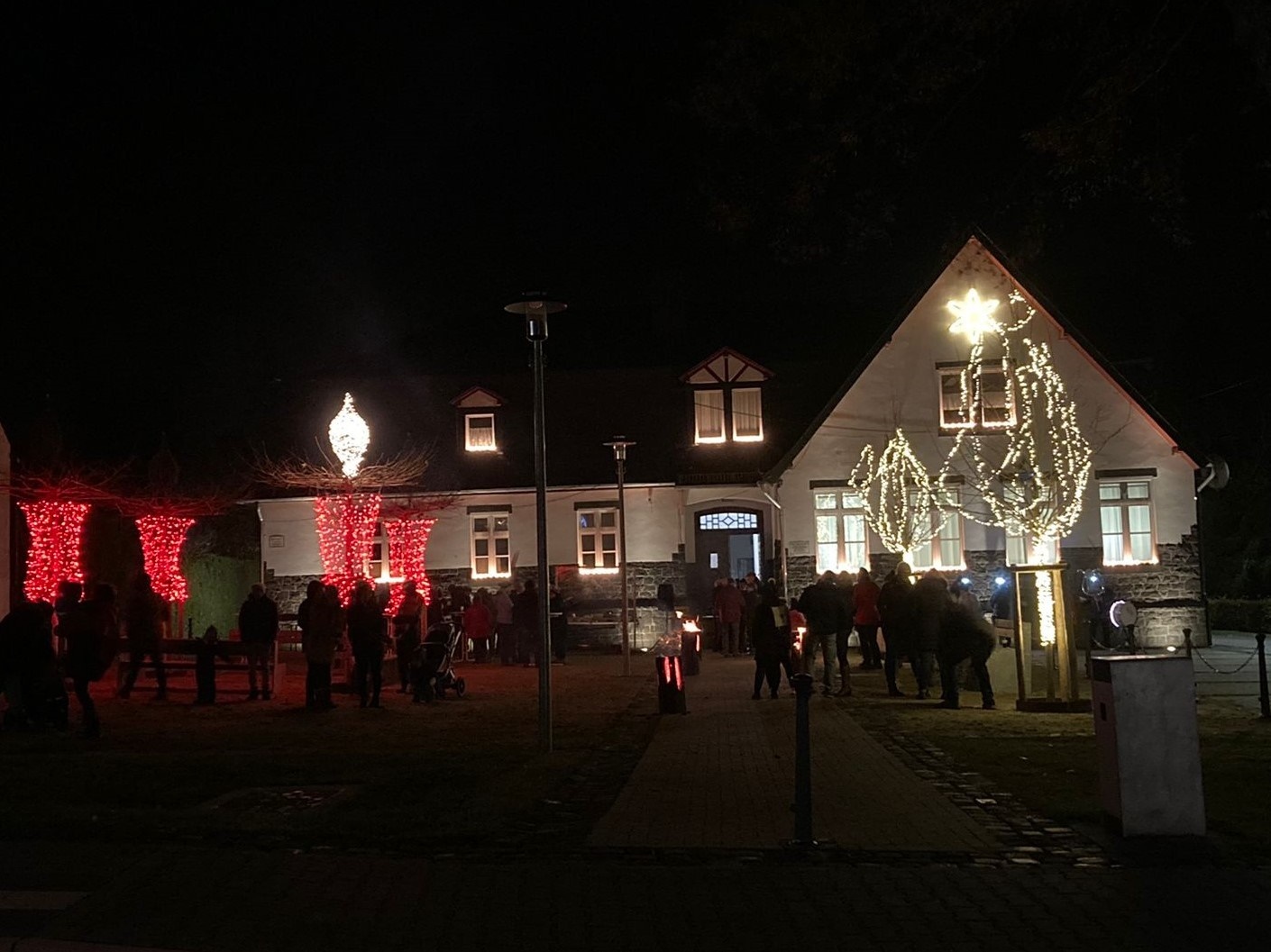Weihnachtlich beleuchteter Platz im Dunkeln - es ist zu Adventskranz zu erkennen