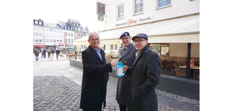 Oberst Dr. Ferdi Akaltin und Oberbürgermeister Dirk Meid während der diesjährigen Haus- und Straßensammlung draußen auf dem Marktplatz in grau gekleidet