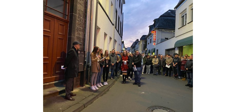 Viele Menschen stehen in einer Straße - vorne sind einige Mädchen, die etwas vorlesen