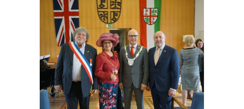 4 Personen stehen für ein Bild zusammen