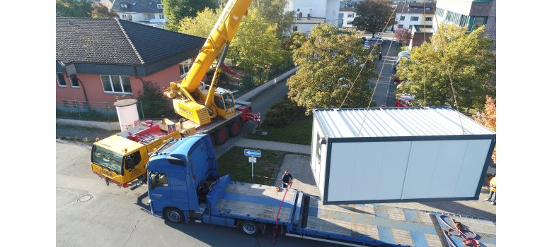 Container wird mit dem Kran von LKW abgeladen