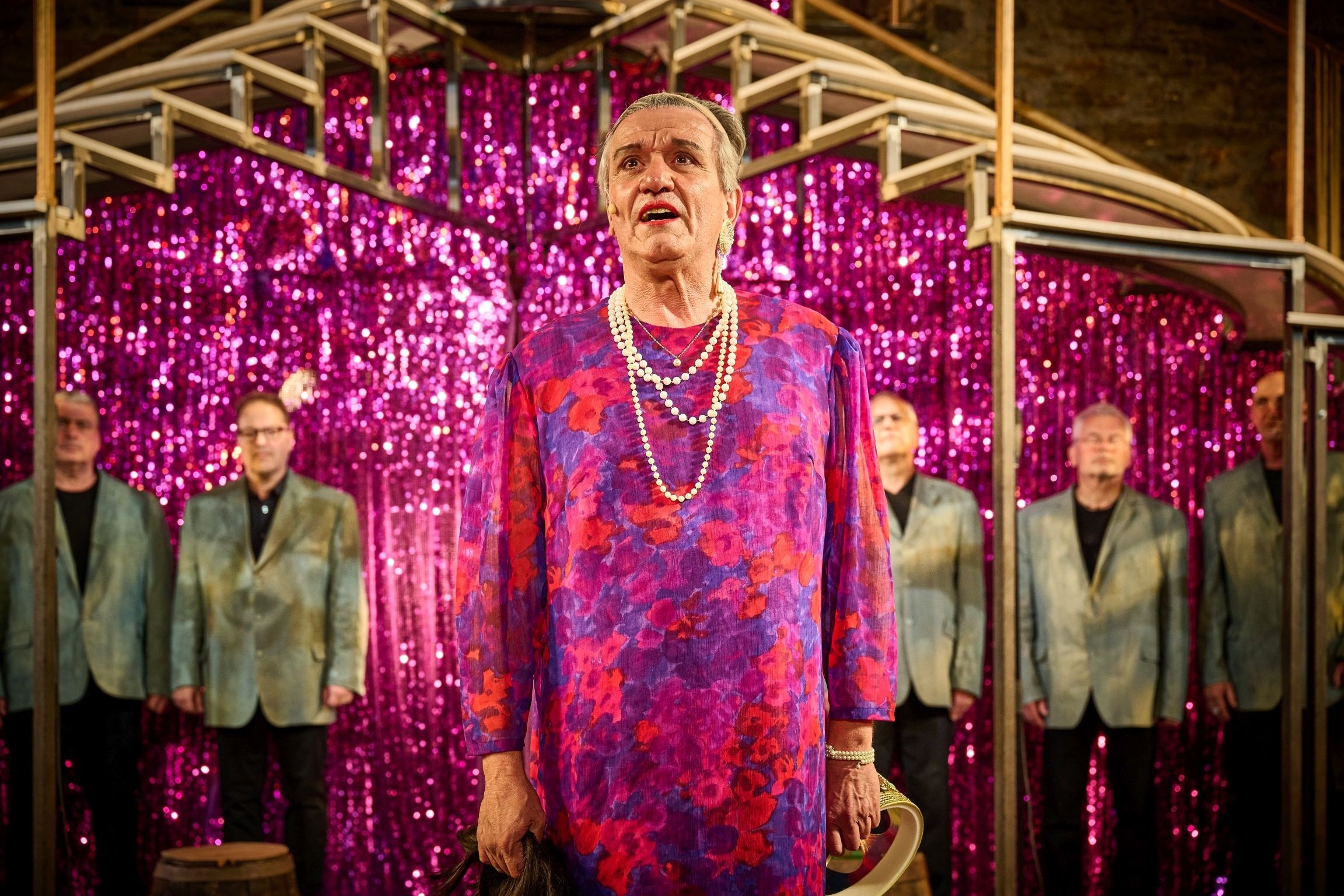 Szenefoto von einem Mann, der als Frau verkleidet ist