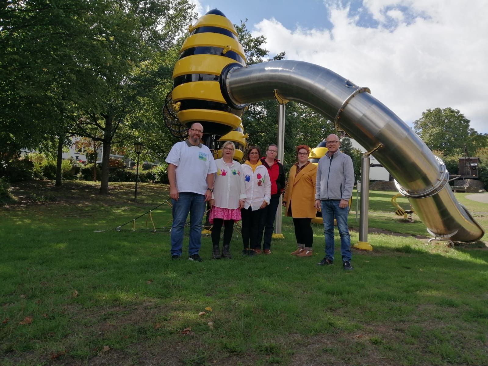 Sechs Personen vor einer Rutsche auf einer Wiese