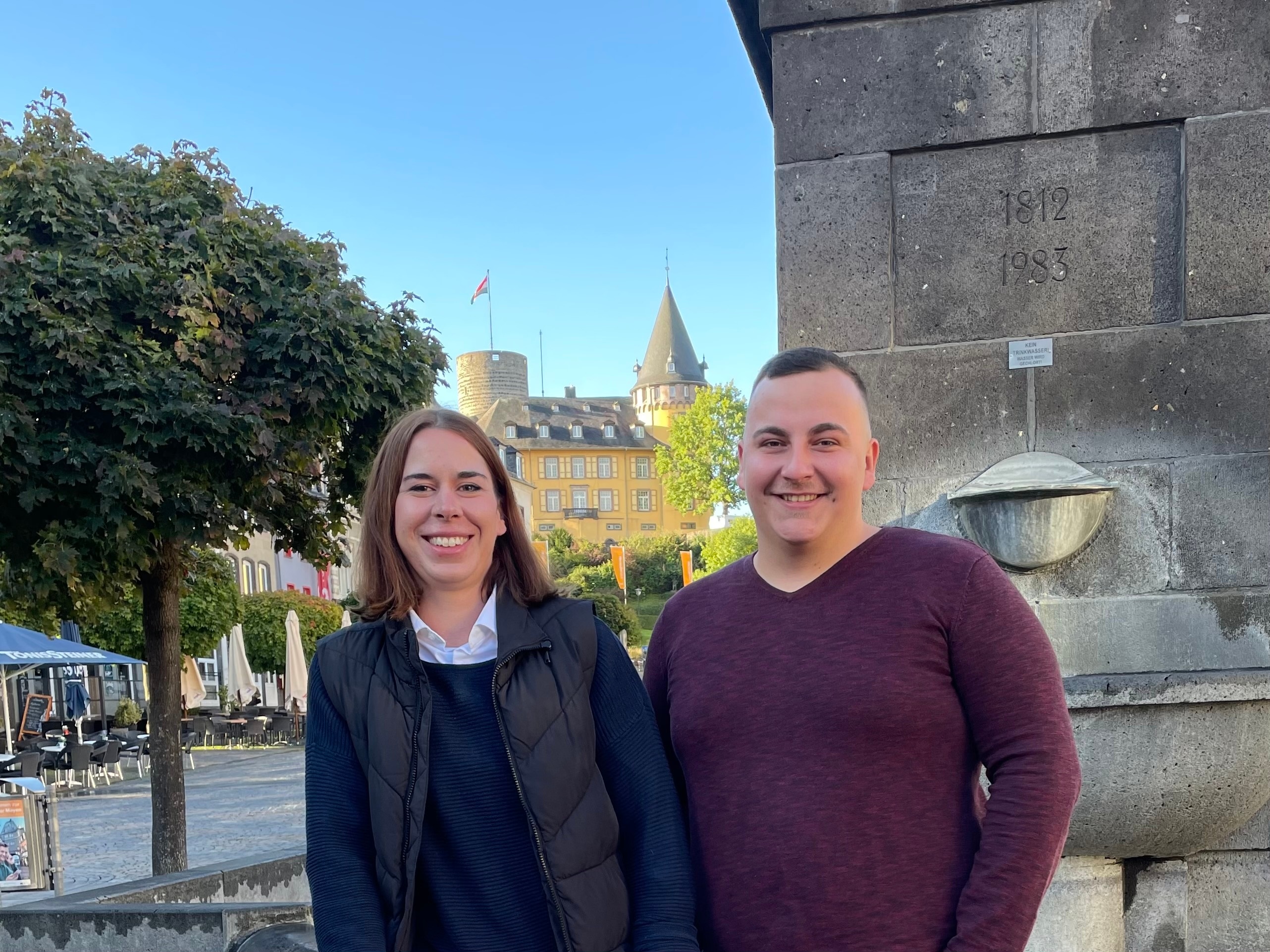 Yvonne Müller und Bastian Kirch vor dem Marktbrunnen und der Genovevaburg