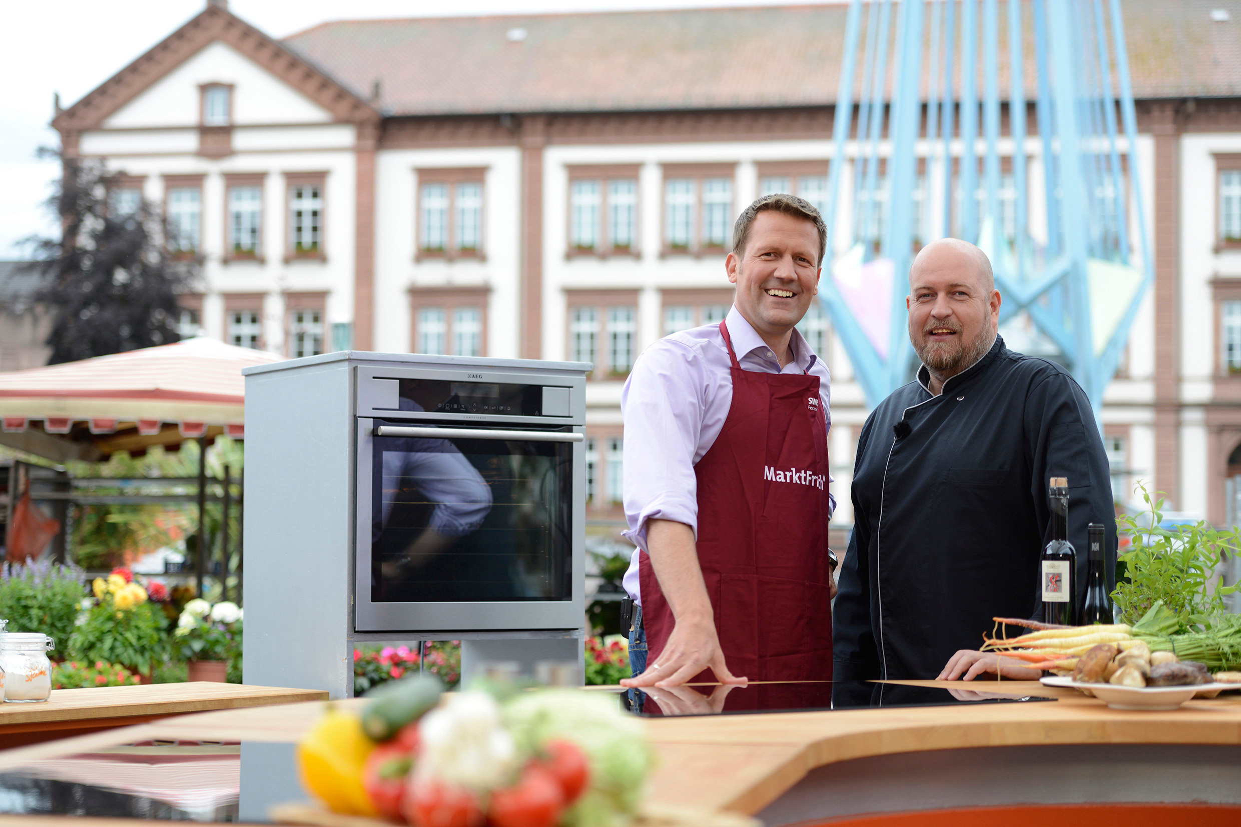 2 Personen stehen in einer Küchenumgebung im Freien