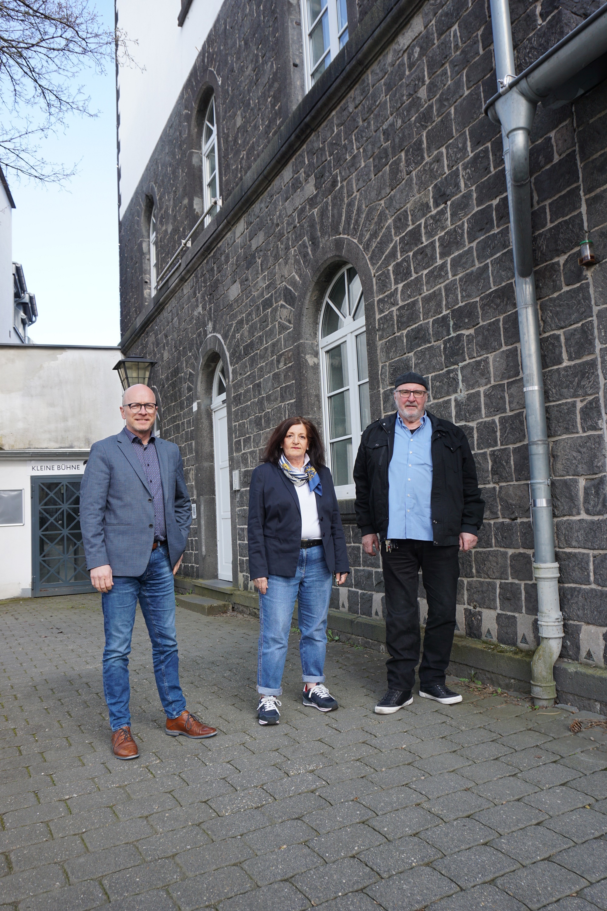 3 Personen stehen zu einem Gruppenfoto zusammen