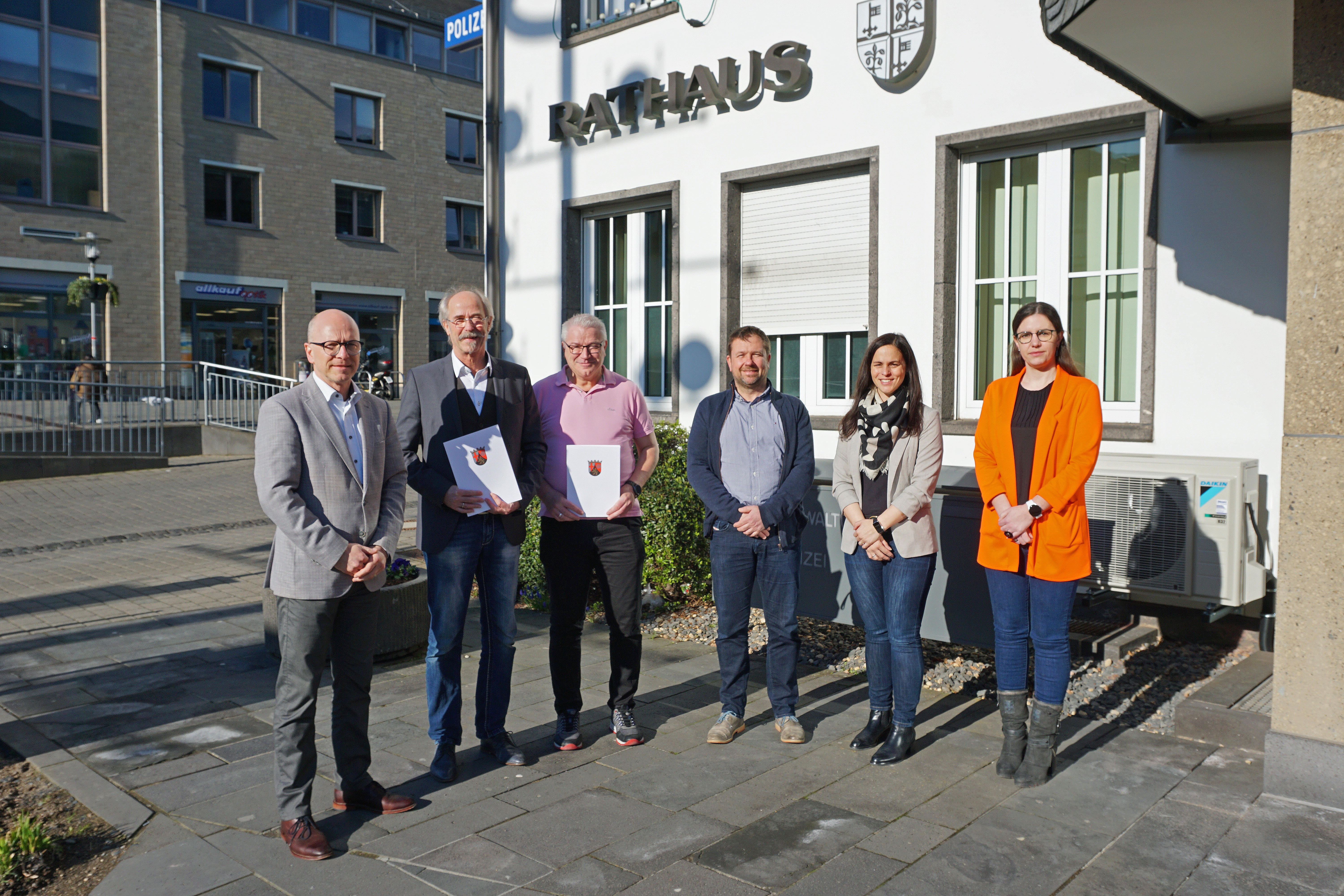 6 Personen stehen vor dem Rathaus