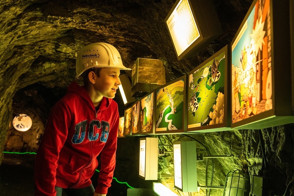 Junge mit Helm schaut sich Bilder an