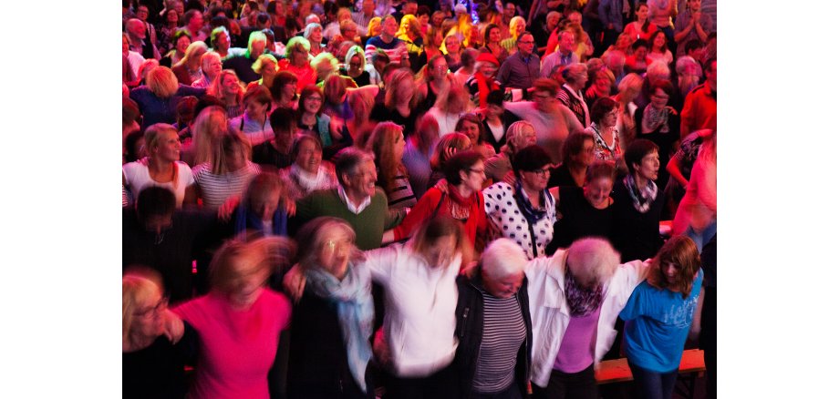 Menge von Menschen liegt sich in den Armen 