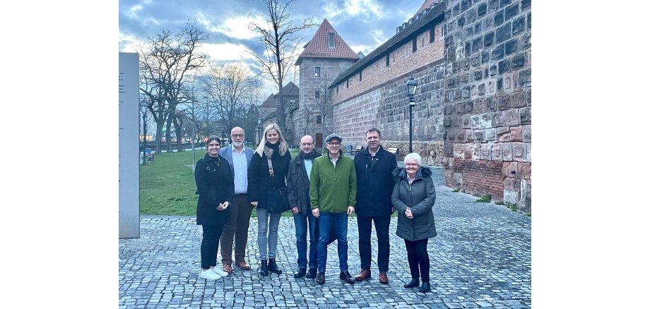 Sieben Personen stehen zu einem Gruppenfoto zusammen