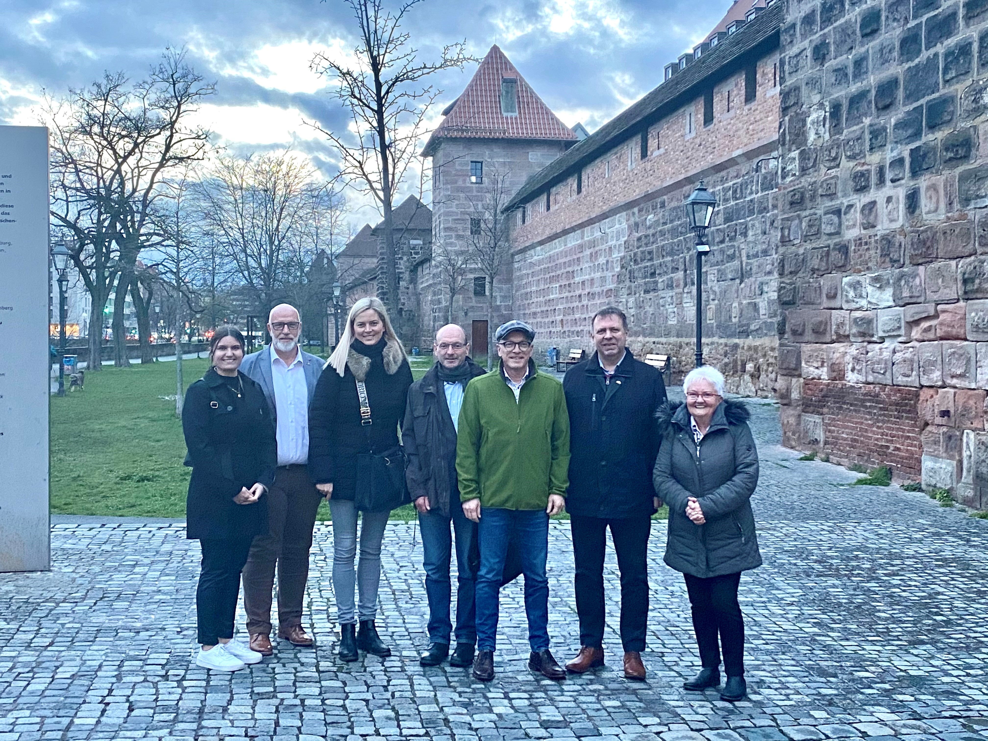 Sieben Personen stehen zu einem Gruppenfoto zusammen